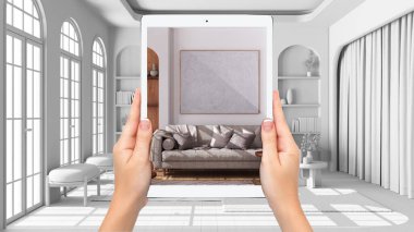 Hands holding tablet showing living room in japandi style, total blank project background, augmented reality concept, application to simulate furniture and interior design products
