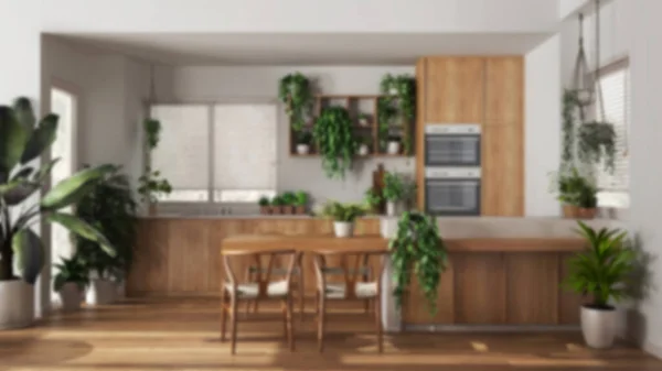 Blurred background, urban jungle interior design, wooden kitchen with many houseplants. Island with chairs and appliances. Biophilic concept idea