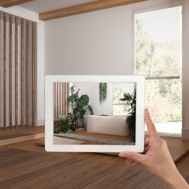 Gelişmiş gerçeklik kavramı. Boş ahşap iç kısımlarda, kentsel orman banyosunda mobilya ve tasarım ürünleri simülasyonu için kullanılan AR uygulamalı el bilgisayarı tableti.