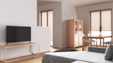 Bulanık bir arka plan, minimum oturma ve yemek odası. Kadife kanepe, sandalyeli ahşap masa, dolaplar ve bölme duvarı. İskandinav iç tasarımı