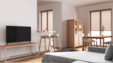 Arka planda bulanıklık, en az ahşap oturma ve yemek odası. Koltuk, sandalyeli japandi masası, dolaplar ve duvar, tabureli ada. İskandinav iç tasarımı