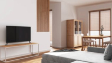 Arka planda bulanıklık, minimum ahşap yemek ve oturma odası. Kadife kanepe, duvar ve televizyon standı. Dolaplar ve masa. İskandinav iç tasarımı