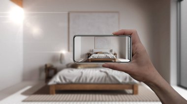 El ele tutuşan akıllı telefon, AR uygulaması, gerçek evde mobilya ve iç tasarım ürünleri simülasyonu, mimar tasarım konsepti, bulanık arka plan, japandi yatak odası