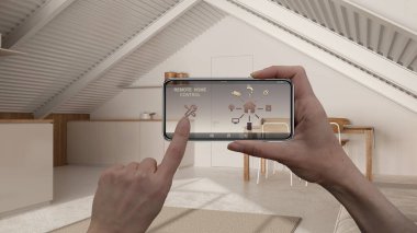 Dijital akıllı telefon tabletindeki uzaktan kumanda sistemi. Uygulama simgeleri olan aygıt. Arka planda asgari asma kat mutfak ve yemek odası, mimari tasarım.