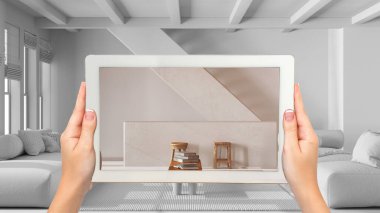 Gelişmiş gerçeklik kavramı. El ele tutuşma tableti ve AR uygulaması beyaz arka planda mobilya ve tasarım ürünleri simülasyonu için kullanılır, merdivenli minimum oturma odası