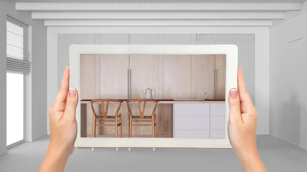 Augmented reality concept. Hand holding tablet with AR application used to simulate furniture and design products in total white background, kitchen with dining island