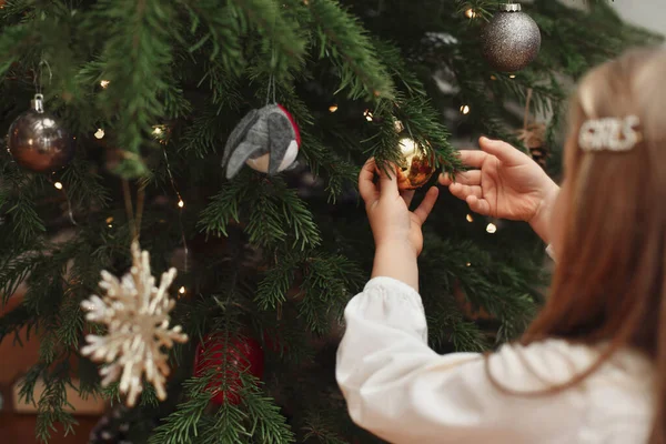 女の子はクリスマスのために木を飾る — ストック写真