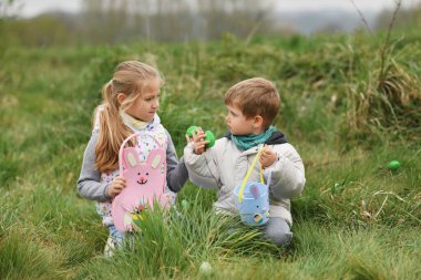 Children collects the eggs in a basket Easter