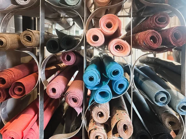 Row with rolls of fabric lie in the store