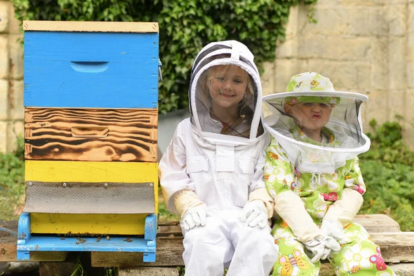 Kinder Schutzanzügen Bienenstock Stockbild