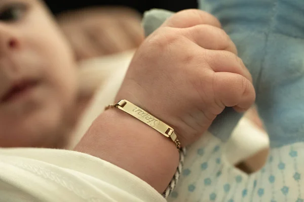 洗礼仪式后戴着金手镯的婴儿 — 图库照片