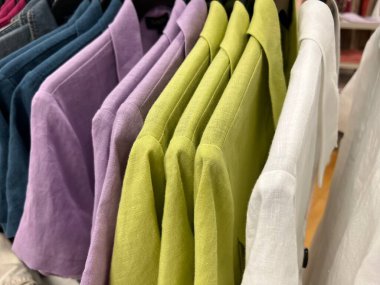 Keten kadın ceketleri mağazadaki askıda asılı.