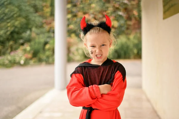 Scary girl dressed as a devil with horns