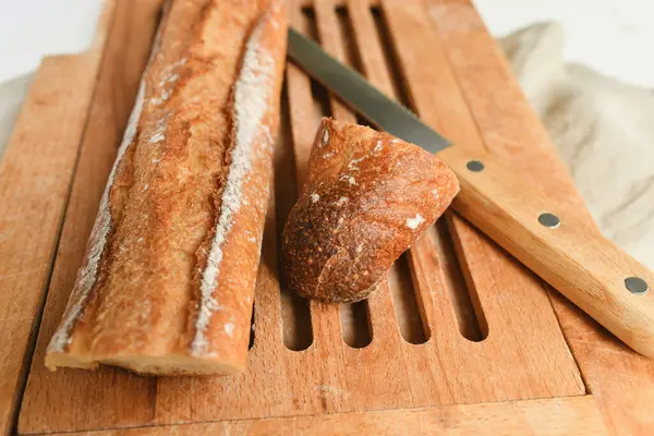 French baguette on a wooden board and knife