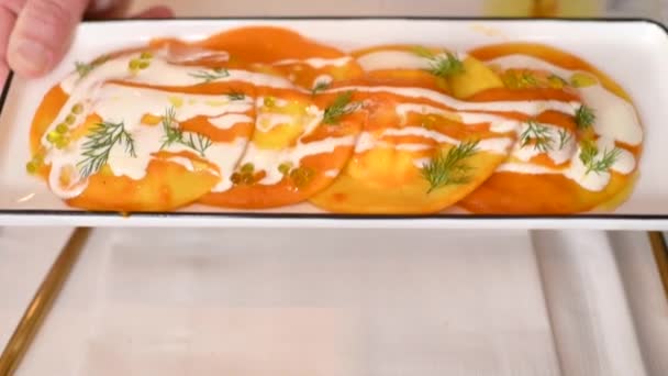 Große Ravioli Mit Orangensoße Und Rotem Kaviar Einem Rechteckigen Teller — Stockvideo