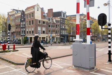 AMSTERDAM, NETHERLANDS - 16 Nisan 2019: Bisikletli bisikletçiler yeşil ışık için bekliyorlar