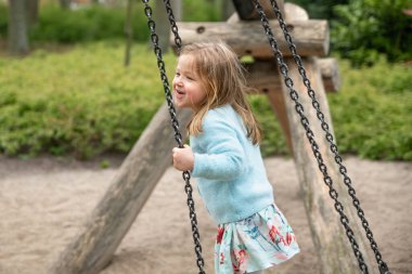 Parkta salıncakta sallanan bir kız
