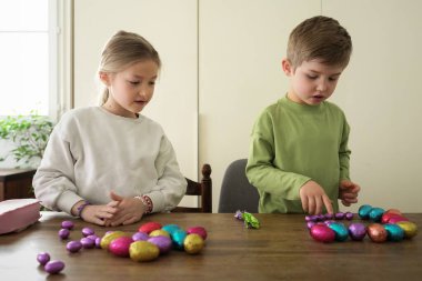 Evdeki çocuklar çikolatalı yumurta topluyor.