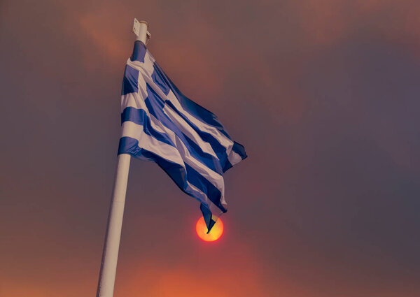 Greek flag on the background of smoke from fires in Greece