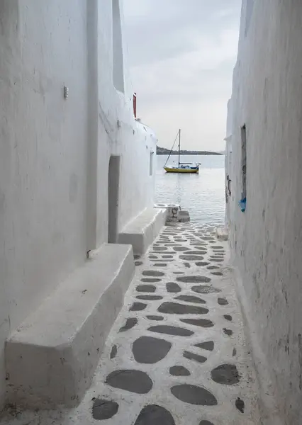 ギリシャのミコノス島の海とヨットを見下ろすリトルヴェネツィアの狭い通り ロイヤリティフリーのストック画像