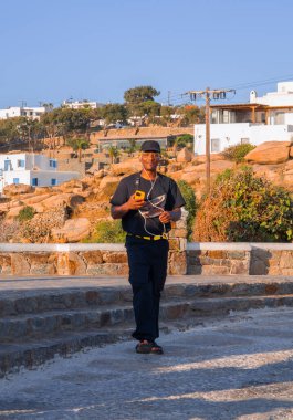 Sarı saçlı siyah bir adam Yunanistan 'daki Mykonos adasında tatil yapıyor.