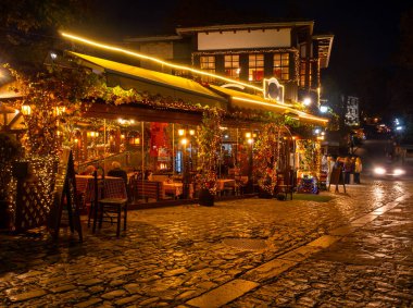 Yunanistan 'ın Epirus dağlarındaki Metsovo kasabasında akşam saatlerinde geleneksel Yunan mutfağına sahip sokaklar ve meyhaneler aydınlatıldı