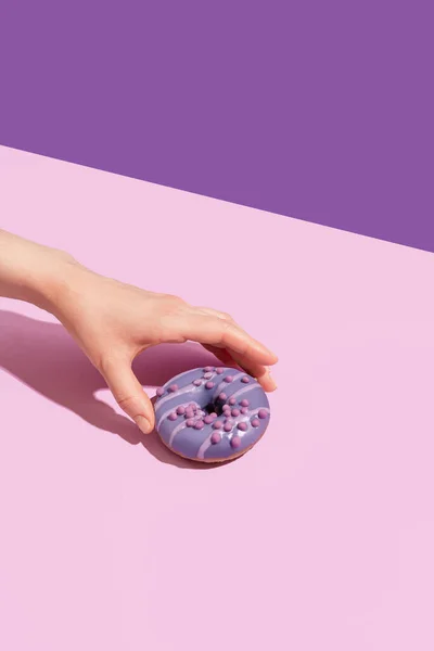 Eine Hand Mit Einem Leckeren Donut Auf Einem Farbigen Hintergrund — Stockfoto