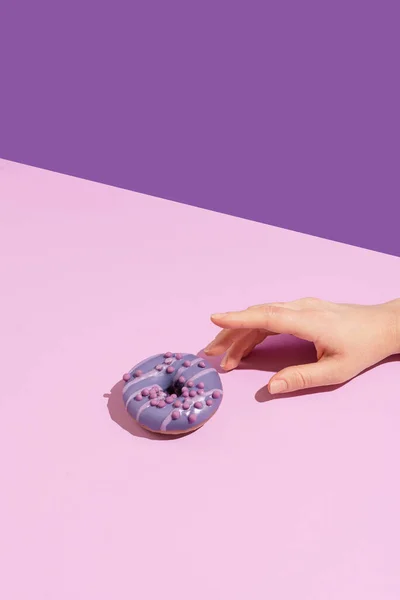 Eine Hand Mit Einem Leckeren Donut Auf Einem Farbigen Hintergrund — Stockfoto