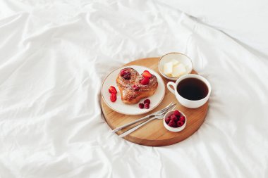 Sevgililer Günü için romantik kahvaltılı tahta tepsi beyaz yumuşak yatakta, kopyalama alanı.