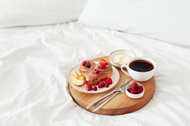 Sevgililer Günü için romantik kahvaltılı tahta tepsi beyaz yumuşak yatakta, kopyalama alanı.
