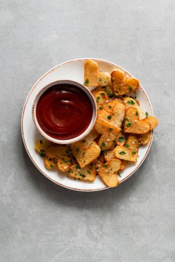 Sevgililer Günü kızarmış patates kalplerini beton arka planda beyaz bir tabakta. Sevgililer Günü için romantik yemek fikirleri, kopyalama alanı