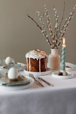 Mutlu Paskalyalar! Paskalya bayramı bahar sofrası dekorasyonu, yumurta, paskalya pastası, vazoda söğüt dalları. Paskalya aile yemeği ya da kahvaltı konsepti
