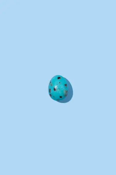 Mavi Benekli Bir Paskalya Yumurtası Mavi Arka Plana Gölge Düşürüyor Stok Resim