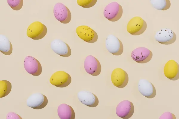 Beyaz Pembe Sarı Renklerde Bej Arka Planda Çikolatalı Paskalya Yumurtaları - Stok İmaj