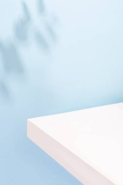 Ürün sunumu için beyaz podyum, güzel gölgeli mavi bir zemin üzerinde. Ürün sunumu için renkli yaz arkaplanı, kopyalama alanı