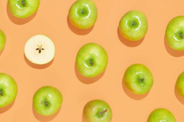 Pastel turuncu arka planda elmalar. Yaz ya da sonbahar meyvesi, lezzetli ve sağlıklı atıştırmalıklar. Yaratıcı gıda konsepti. Üst görünüm