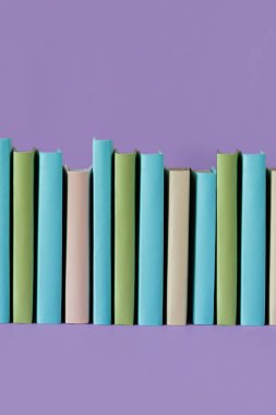 Pastel mor arkaplanlı kitaplar, yumuşak gölgeli, kopyalama alanı. Eğitim, Eğitim ve Kitap Aşıkları Günü konsepti