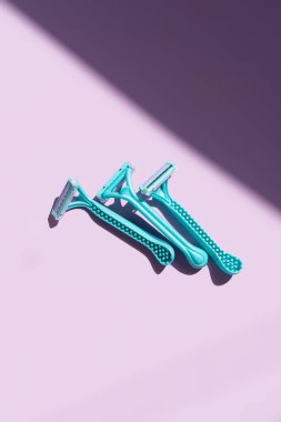 Mor arka planda kontrast gölgeli mavi jiletler. Kişisel bakım ve bakım konsepti. Üst görünüm, alanı kopyala