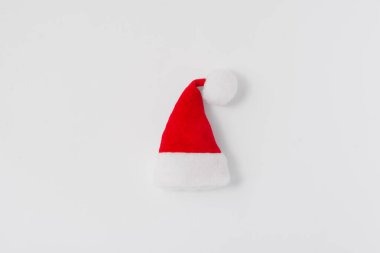 Beyaz arka planda kırmızı Noel Baba şapkası, üst manzara, kopyalama alanı. Noel minimalist konsepti, tatil teması