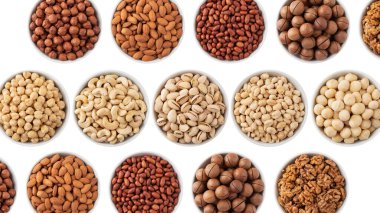 Beyaz arka planda izole edilmiş bir sürü fındık var. Fındık, fındık, fıstık, fıstık, fıstık, ceviz ve macadamia fındığı.