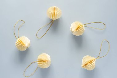 Açık mavi arka planda bir Noel ağacını süslemek için bej kağıt süsler. Kutlama havası ve dekorasyon Noel ağacı konsepti, üst görünüm, kopyalama alanı