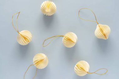 Açık mavi arka planda bir Noel ağacını süslemek için bej kağıt süsler. Kutlama havası ve dekorasyon Noel ağacı konsepti, üst görünüm, kopyalama alanı