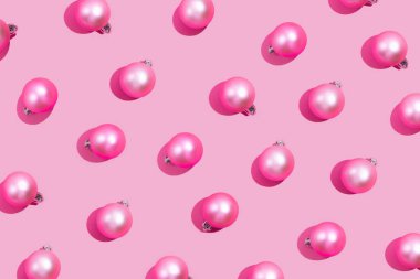 Pastel pembe arka planda matte noel toplarının yaratıcı deseni. Yaratıcı Noel pembe arka planı, üst görünüm
