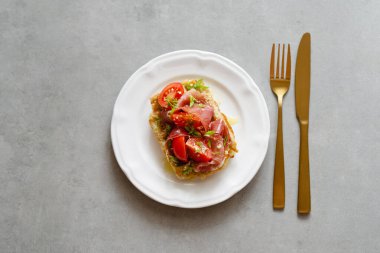 Jambon, domates ve çimento kaplı çatal bıçaklı otlarla servis edilen Belçika patatesli waffle 'lar. Sağlıklı kahvaltı, lezzetli waffle, güzel manzara.