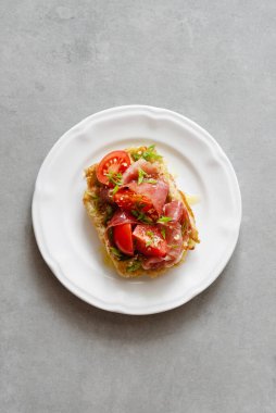 Jambon, domates ve çimento kaplı çatal bıçaklı otlarla servis edilen Belçika patatesli waffle 'lar. Sağlıklı kahvaltı, lezzetli waffle, güzel manzara.