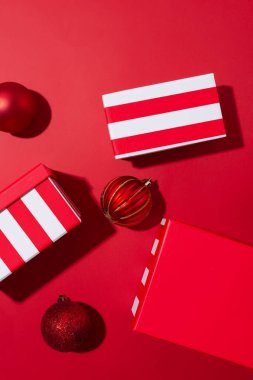 Kırmızı zemin üzerinde beyaz çizgili üç kırmızı set Noel hediyesi kutuları farklı boyutlarda. Asgari Noel ya da yeni yıl hediyeleri konsepti. Monokrom renk şeması, üst görünüm, boşluk kopyala
