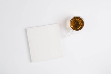 Beyaz arka planda çay fincanı olan beyaz bir defter. Yeni yıl için hedefler ve planlar kavramı. Farkındalık kavramı, üst görünüm, kopyalama alanı