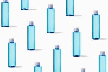 Beyaz arka planda kozmetik ürünü olan mavi şeffaf şişe deseni. Cilt bakımı ürünleri. Güzellik ürünleri içeren şeffaf dağıtıcılar.