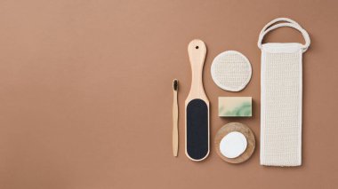 Kahverengi arka planda banyo aletleri ve organik kozmetik ürünlerinin üst görünümü doğal, çevre dostu güzellik gereksinimlerini ve kişisel bakım rutin konseptini vurguluyor. Doğal cilt bakımı ve sağlıklı yaşam ürünleri. 