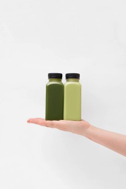 Plastik şişeler dolusu taze vejetaryen smoothie beyaz arka planda. Sağlık ve sağlıklı beslenme konsepti. Yaratıcı yiyecek ve içecek fotoğrafçılığı, kopyalama alanı